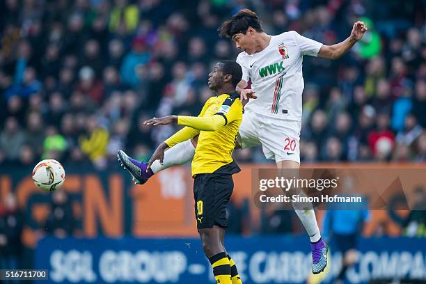 Jeong-Ho Hong of Augsburg jumps for a header with Adrian Ramos of Dortmund during the Bundesliga match between FC Augsburg and Borussia Dortmund at...