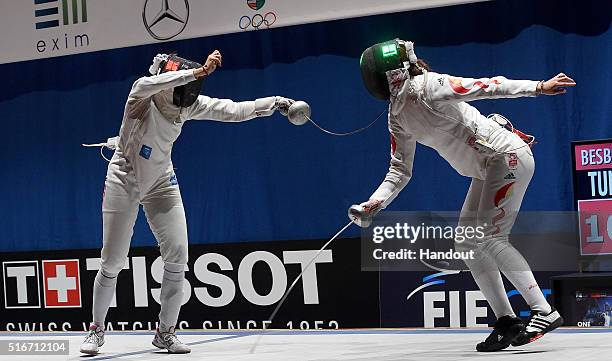 In this handout image provided by the FIE, Sarra Besbes of Tunisia and Xu Anqi of China compete during the individual women's epee match on day 3 of...