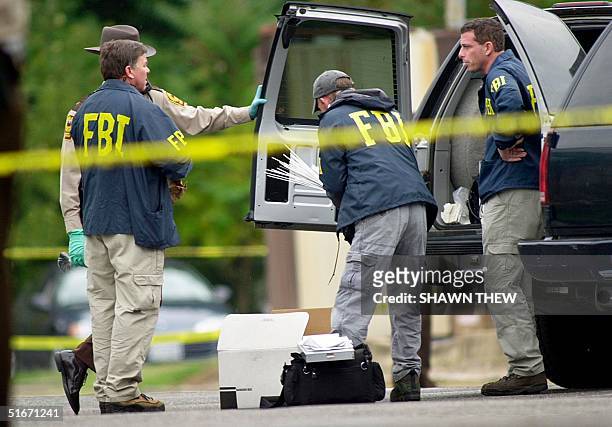 Agents load supplies into a truck 20 October 2002 in front of the Ponderosa Steak House where a 37 year old man was shot late 19 October in Ashland,...