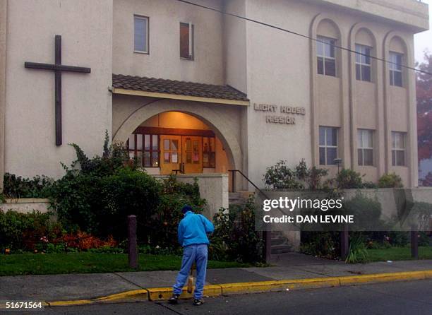 Lone worker sweeps up during the early hours of 24 October 2002 in front of the Light House Mission, a men's shelter in Bellingham, Washington, 85...