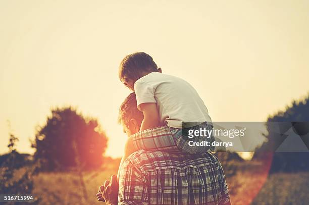 fatherhood - carrying on shoulders stock pictures, royalty-free photos & images