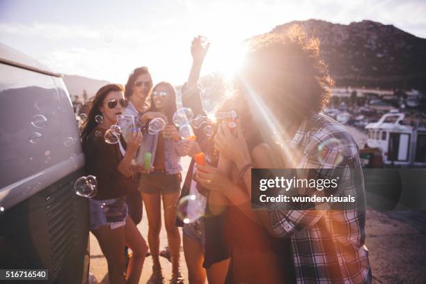 happy hipster friend partying with bubbles outside at sunset - bubbles happy stockfoto's en -beelden