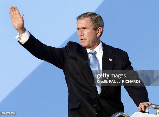 President George W. Bush waves from atop the steps of Air Force One at Andrews Air Force base in Washington, DC before traveling to Cincinnati, Ohio...