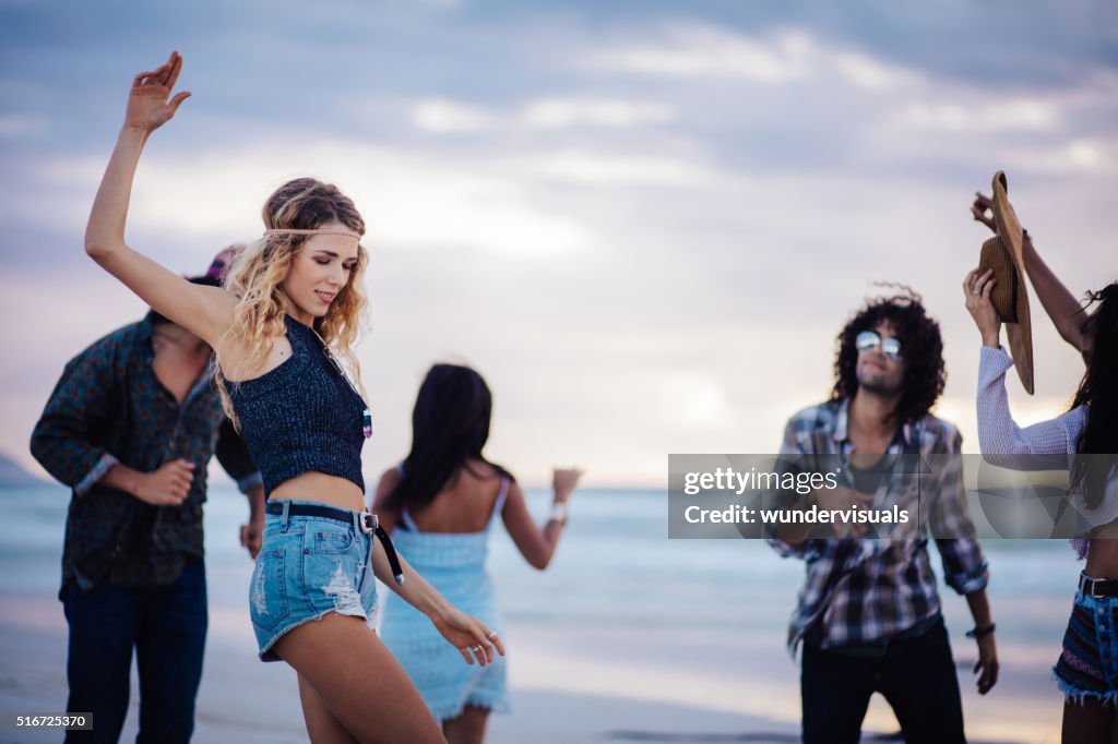 Hipster Freunde tanzen am Sandstrand am Meer