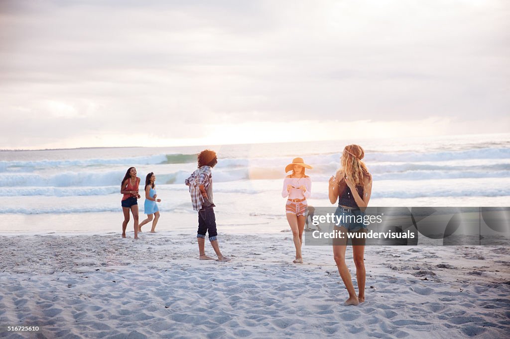 Multiethnischen Freunde stehen und spielt am Strand