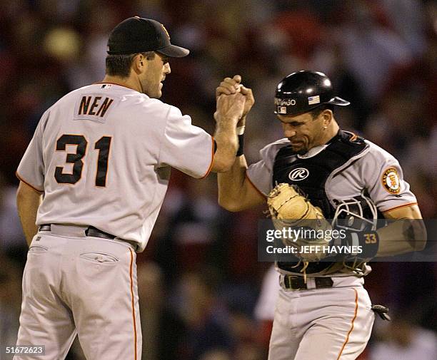 Relief pitcher Robb Nen of the San Francisco Giants is congratulated by catcher Benito Santiago 10 October 2002, after game two of the National...