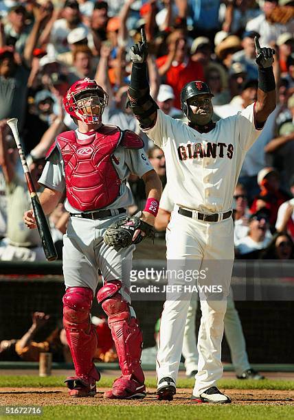 Barry Bonds of the San Francisco Giants and catcher Mike Matheny of the St. Louis Cardinals watching while Bonds' three-run home run sails out of the...
