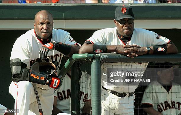 Barry Bonds and manager Dusty Baker of the San Francisco Giants watch from the dugout 12 October 2002, during game 3 of the National League...