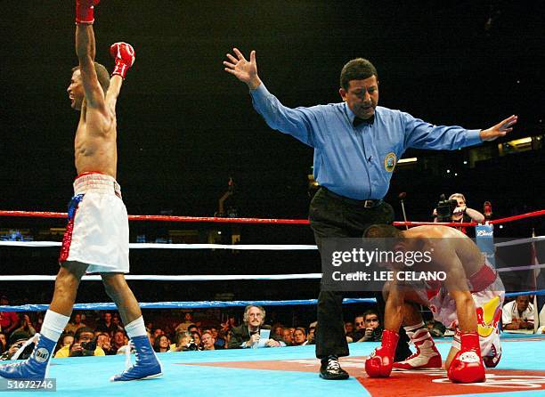 Kaowichit Denkaosaen of Thailand stays on his knees after being knocked down by Eric Morel of the United States in the 11th round of their World...