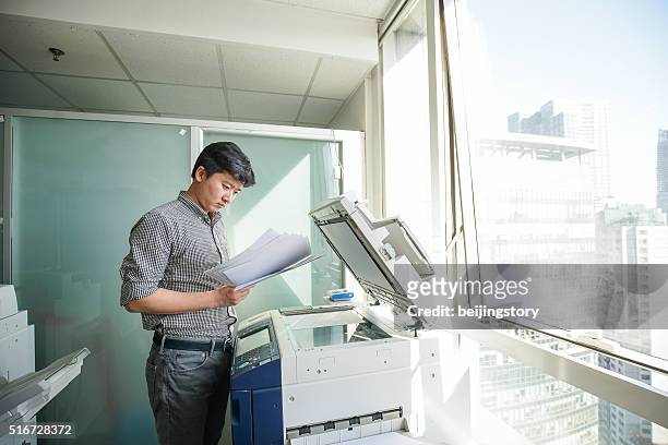 asiatiche uomo d'affari in ufficio-copia file - stampatore foto e immagini stock