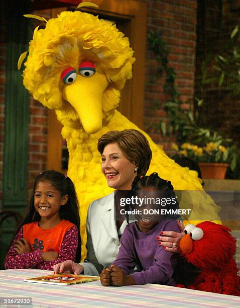 First Lady Laura Bush laughs with Big Bird and Elmo 19 September, 2002 while taping a show of Sesame Street in New York. The children, Sydney...