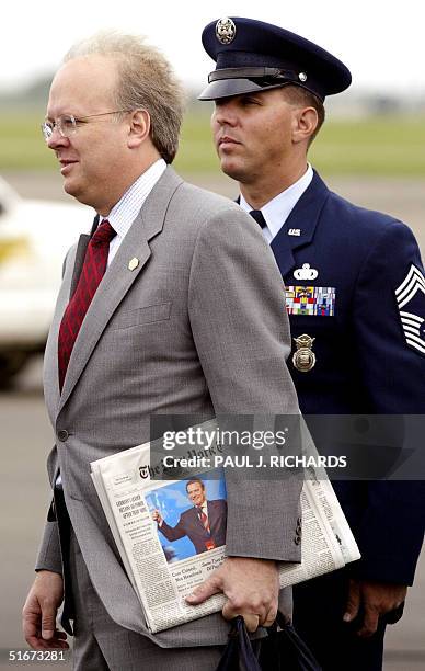 Senior Advisor to US President George W. Bush, Karl Rove, carries a copy of the 23 September New York Times with a photo of narrowly re-elected...
