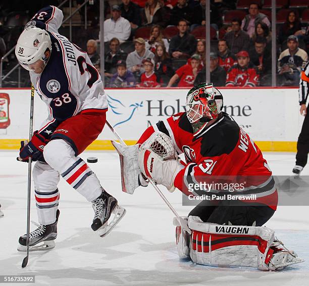 Goalie Scott Wedgewood of the New Jersey Devils plays a tip shot by Boone Jenner of the Columbus Blue Jackets during the first period of an NHL...