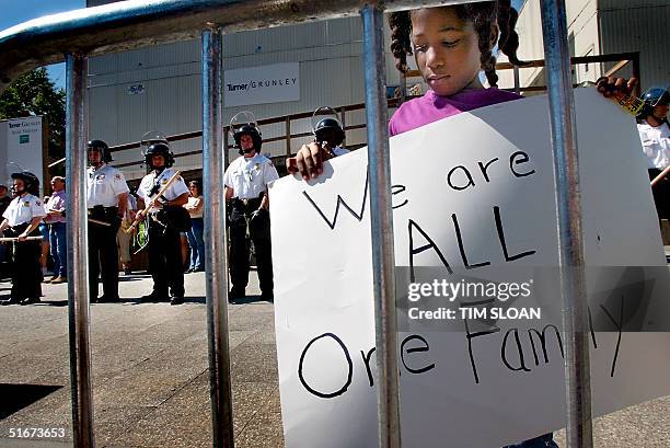Eight-year-old Jayla Oliver of Baltimore, Maryland, stands with a sign outside the Treasury Department, which is guarded by Secrect Service officers...