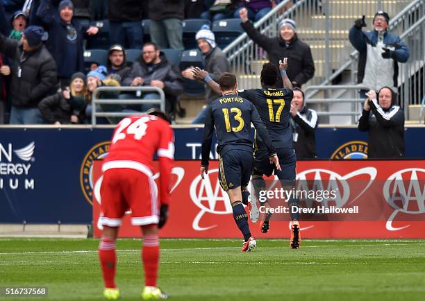 Sapong and Chris Pontius of Philadelphia Union run towards the crowd celebrating as Lee Nguyen of New England Revolution looks down at Talen Energy...