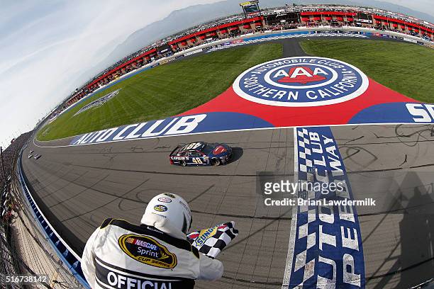 Jimmie Johnson, driver of the Lowe's / Superman Chevrolet, takes the checkered flag to win the NASCAR Sprint Cup Series Auto Club 400 at Auto Club...