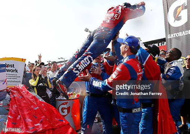 Jimmie Johnson, driver of the Lowe's / Superman Chevrolet, dives into his crew members in victory lane after winning the NASCAR Sprint Cup Series...