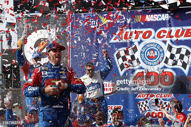 Jimmie Johnson, driver of the Lowe's / Superman Chevrolet, celebrates in victory lane after winning the NASCAR Sprint Cup Series Auto Club 400 at...