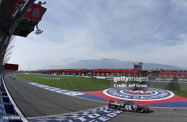 Jimmie Johnson, driver of the Lowe's / Superman Chevrolet, takes the checkered flag to win the NASCAR Sprint Cup Series Auto Club 400 at Auto Club...