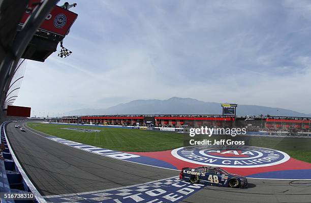 Jimmie Johnson, driver of the Lowe's / Superman Chevrolet, takes the checkered flag to win the NASCAR Sprint Cup Series Auto Club 400 at Auto Club...