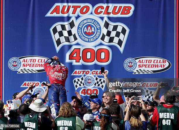 Jimmie Johnson, driver of the Lowe's / Superman Chevrolet, dives into his crew members in victory lane after winning the NASCAR Sprint Cup Series...