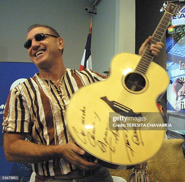 The Venezuelan musician Franco de Vita shows his autographed guitar during a press conference in San Jose, Costa Rica, 7 September 2002. As a part of...