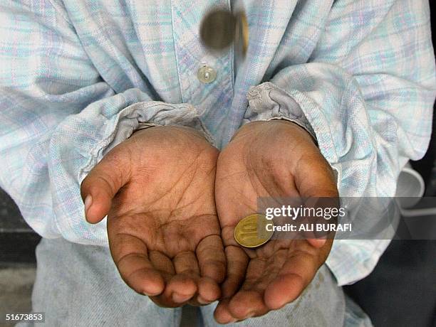 Girl receives alms in the streets of Buenos Aires, Argentina September 2002. The Episcopal Commissin of Aid for the most needy Regions will have...