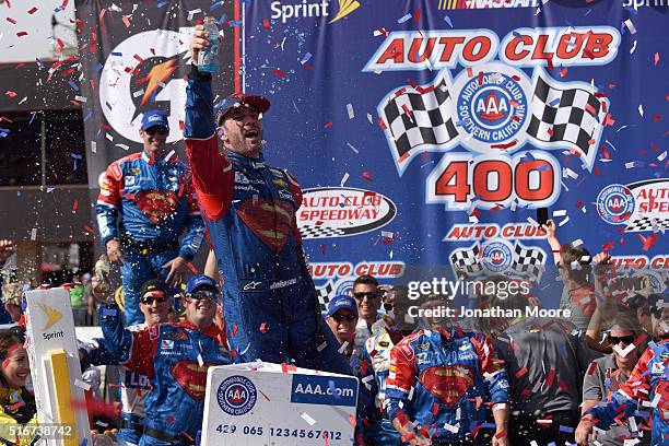 Jimmie Johnson, driver of the Lowe's / Superman Chevrolet, celebrates in victory lane after winning the NASCAR Sprint Cup Series Auto Club 400 at...