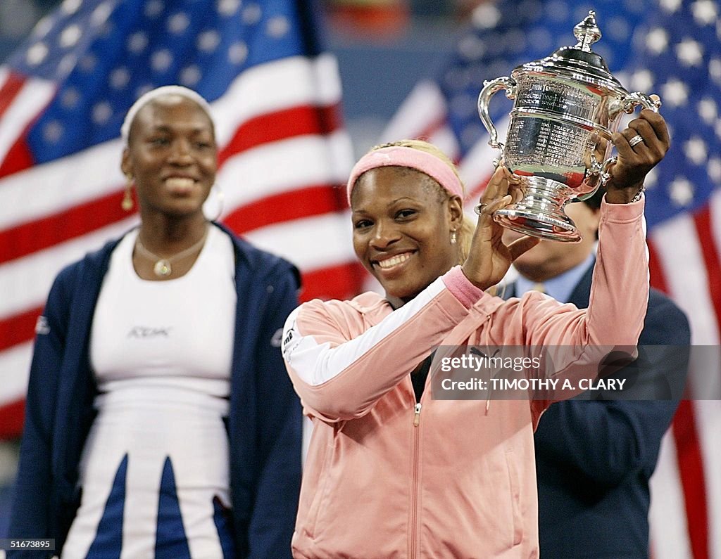 Serena Williams (R) of the US holds up the US Open