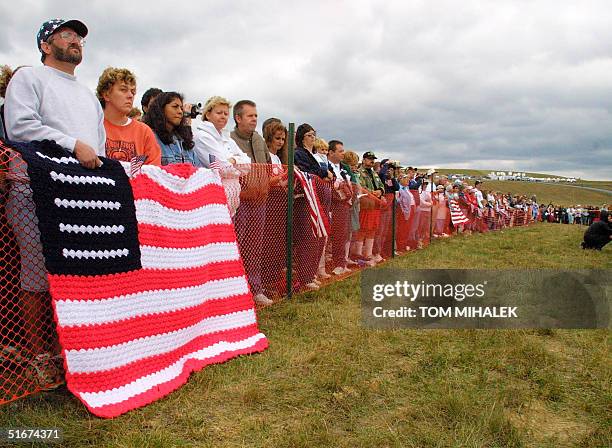 Flags hang on the fence set up in front of a large crowd who attended a memorial service in Shanksville, PA, 11 September, 2002 on the first...