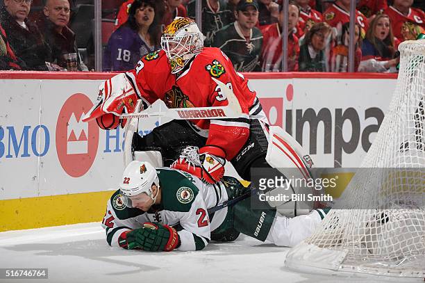 Goalie Scott Darling of the Chicago Blackhawks pushes down Nino Niederreiter of the Minnesota Wild in the first period of the NHL game at the United...