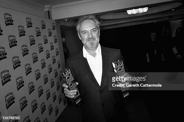 Sam Mendes poses in the winners room with awards for Best British Film and Best Thriller for 'Spectre' at the Jameson Empire Awards 2016 at The...
