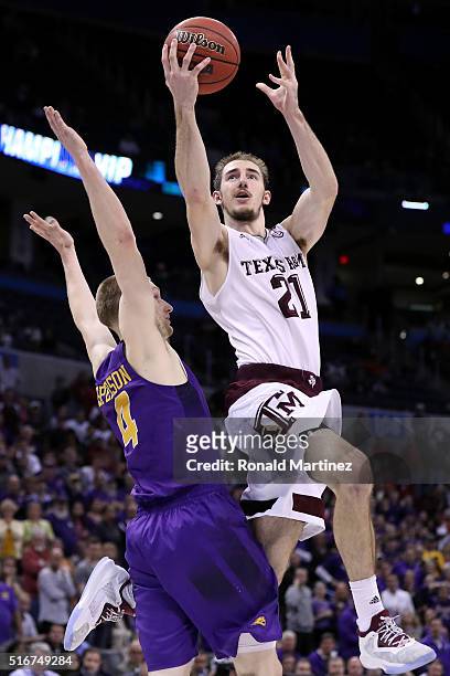 Alex Caruso of the Texas A&M Aggies makes the basket and draws the foul late in the second half against Paul Jesperson of the Northern Iowa Panthers...