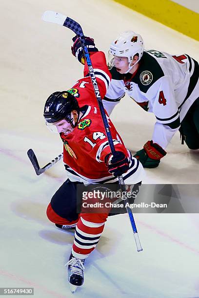 Richard Panik of the Chicago Blackhawks reacts after scoring, as Mike Reilly of the Minnesota Wild kneels on the ice behind, in the second period of...
