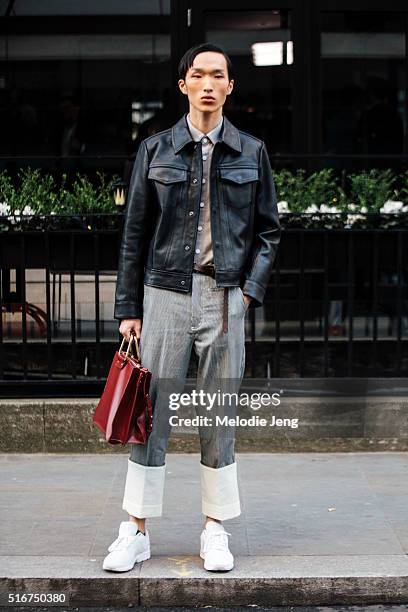 Chinese model Hao Liu exits the Richard James show i in a Loewe outfit including a cropped leather jacket, gray trousers with high white cuffs, white...