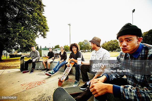 skateboarders relaxing on edge of skate park - friends skating stock pictures, royalty-free photos & images