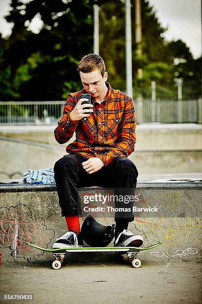 skateboarder taking a picture with a smartphone - one teenage boy only fotografías e imágenes de stock