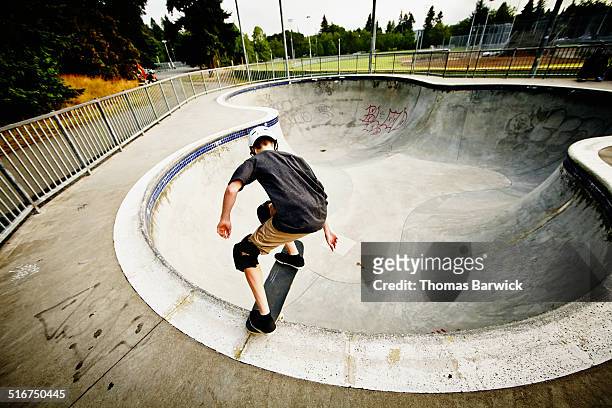 skateboarder dropping into bowl of skate park - one teenage boy only fotografías e imágenes de stock