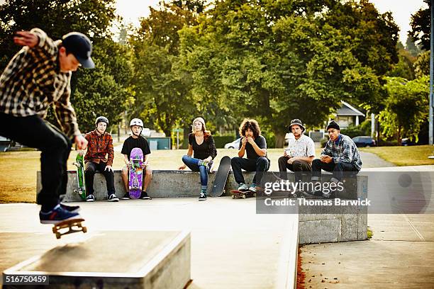 skateboarders hanging out watching friend skate - great american group stock pictures, royalty-free photos & images