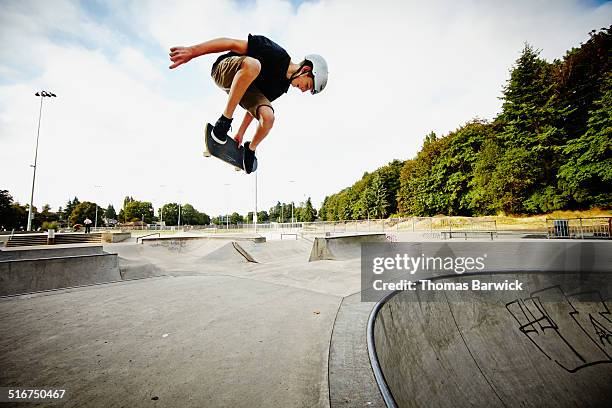 skateboarder in mid air in skate park - boy skatepark stock-fotos und bilder