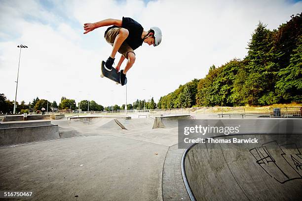 skateboarder in mid air in skate park - skatepark foto e immagini stock