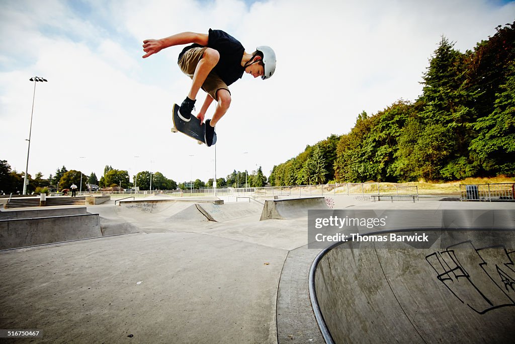 Skateboarder in mid air in skate park