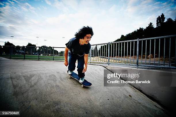 smiling skateboarder riding in skate park - youth culture speed stock pictures, royalty-free photos & images