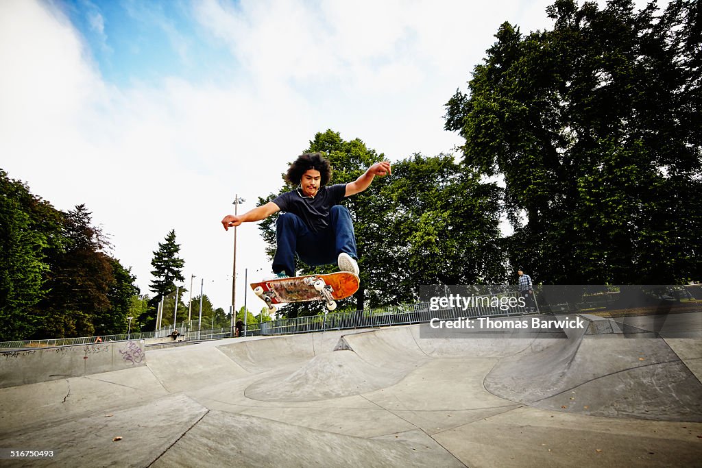 Skateboarder in mid air in skate park