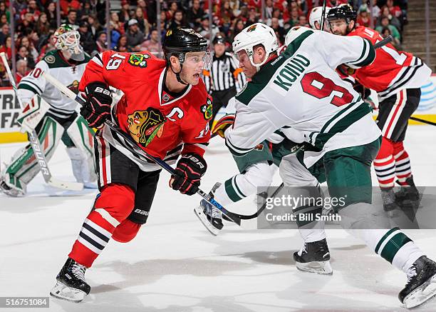 Jonathan Toews of the Chicago Blackhawks and Jarret Stoll of the Minnesota Wild skate in the second period of the NHL game at the United Center on...