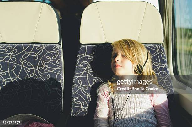 girl on train, relaxing, listening to music on headphones - train interior stock pictures, royalty-free photos & images