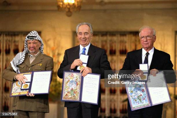 Palestinian leader Yasser Arafat , Israeli Foreign Minister Shimon Peres and Israeli Premier Yitzhak Rabin display their Nobel Peace Prizes December...