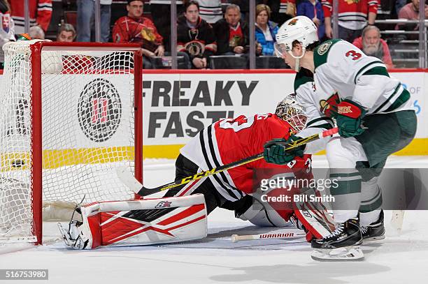 Charlie Coyle of the Minnesota Wild scores the game winning goal against goalie Scott Darling of the Chicago Blackhawks in the shoot-out of the NHL...