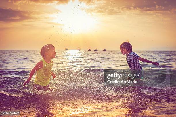 children on the beach - child silhouette ocean stock pictures, royalty-free photos & images