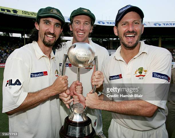 Jason Gillespie, Glenn McGrath and Michael Kasprowicz of Australia celebrate with the Border Gavaskar Trophy after winning the series 2 - 1 with team...